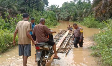 Sungai Batang Gangsal Meluap, Bripka Habibi Turun Tangan Seberangkan Warga