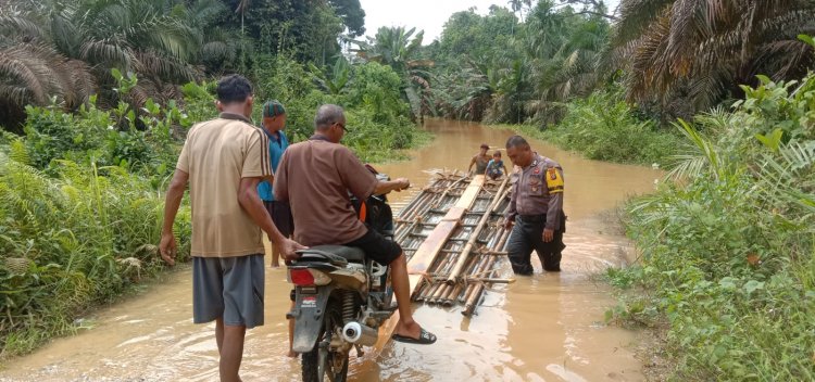 Sungai Batang Gangsal Meluap, Bripka Habibi Turun Tangan Seberangkan Warga